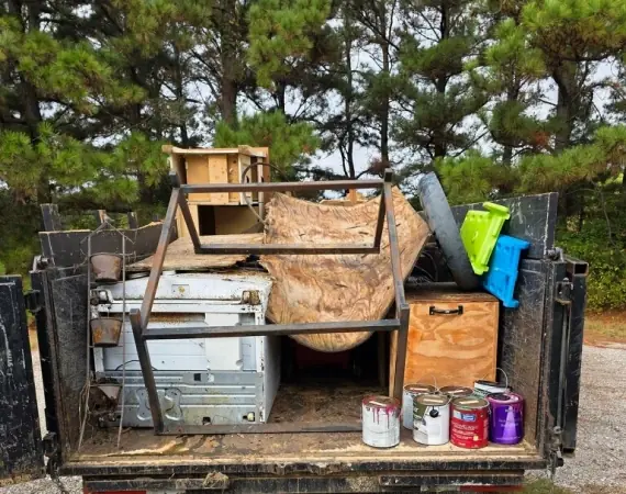 Dump trailer loaded with furniture, cabinets and paint cans