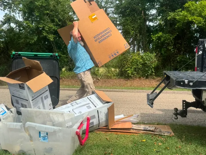 Crew carrying boxes and totes out to the trailer