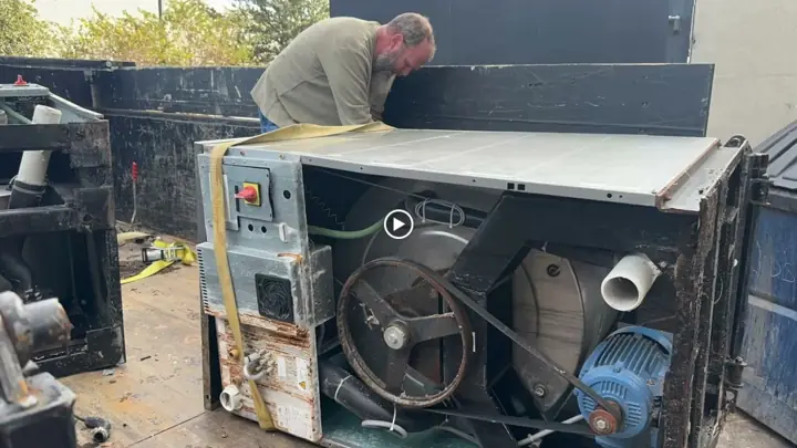 Loading a heavy commercial appliance into the dump trailer
